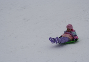 Dzieci zjeżdżają z górki.