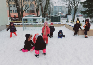 Dzieci bawią się na śniegu.