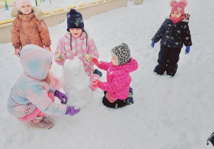 Dzieci lepią bałwana.