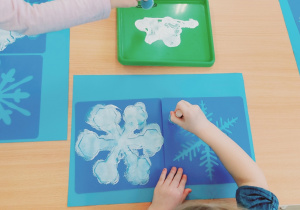Dziecko maluje śnieżki.