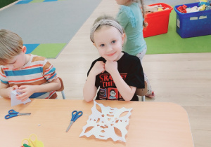 Dziecko prezentuje wycinankę.