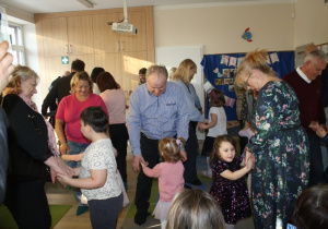 Dzieci tańczą z dziadkami.