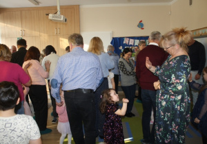 Dzieci tańczą z dziadkami.