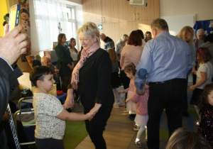 Dzieci tańczą z dziadkami.