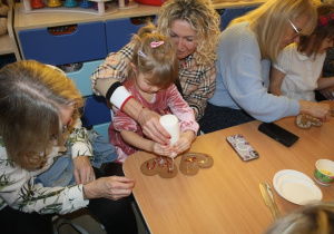 Dzieci dekorują pierniki z dziadkami i babciami.