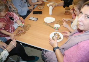 Dzieci dekorują pierniki z dziadkami i babciami.