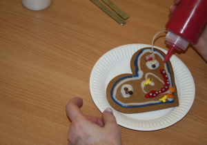 Dzieci dekorują pierniki z dziadkami i babciami.