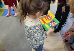 Dziewczynka trzyma laurkę.