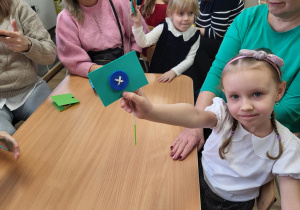 Dziewczynka pokazuje przyszyty guzik.