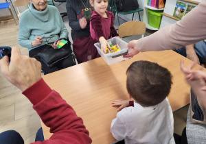 Dziewczynka wyjmuje z pudełka elementy.