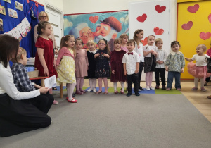 Dzieci stoją na dywanie.