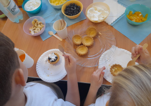 Dzieci przygotowują babeczki z dziadkami.