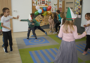 Dzieci uczestniczą w zabawie ruchowej.