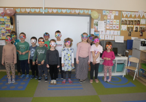 Dzieci prezentują maski karnawałowe.