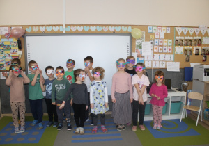 Dzieci prezentują maski karnawałowe.