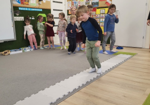 Dziecko przechodzi po ścieżce z puzzli.