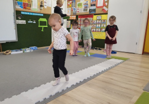 Dziecko przechodzi po ścieżce z puzzli.