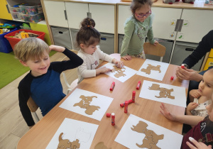 Dzieci wykonują pieska z puzzli.