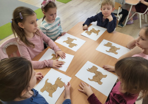 Dzieci wykonują pieska z puzzli.