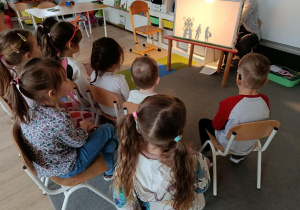 Dzieci oglądają przedstawienie w teatrzyku chińskich cieni.