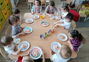 Dzieci wykonują projekt pączka z kolorową posypką.