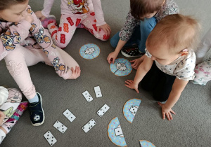 Dzieci grają w grę na dywanie.