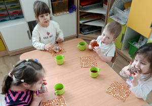 Dzieci jedzą pączki.