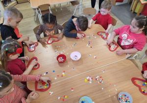 Dzieci wykonują serduszka walentynkowe.