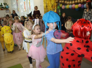 Dzieci tańczą w przebraniach karnawałowych.