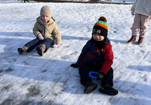 Dzieci zjeżdżają z górki na jabłuszku.