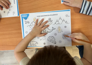 Dzieci kolorują obrazek.