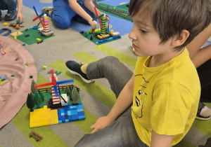 Dzieci budują z klocków Lego.