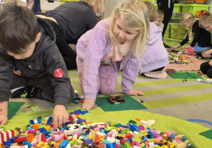 Dzieci budują z klocków Lego.