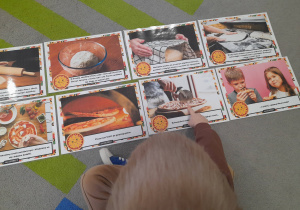 Chłopiec wskazuje palcem na ilustrację.