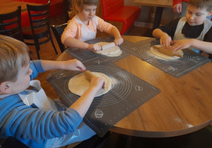 Dzieci wałkują ciasto.