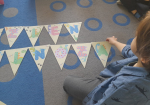 Chłopiec układa napis z liter.