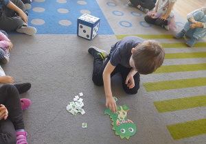 Chłopiec karmi dinozaura.