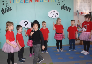 Dzieci z grupy 5 przedstawiają wiersz - w tle detektyw.