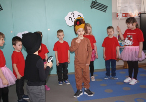 Dzieci z grupy 5 przedstawiają wiersz w tle pies.