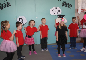 Dzieci z grupy 5 przedstawiają wiersz w tle kot.