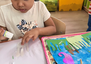 Dziewczynka smaruje klejem.