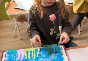 Dziewczynka przykleja.