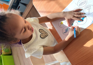 Dziewczynka koloruje.