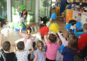 Dzieci machają pomponami do muzyki.