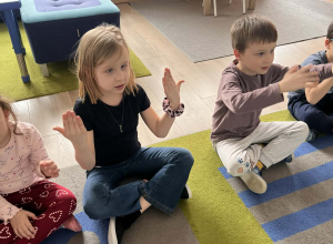 Dzieci pokazują znaki w języku migowym.