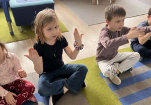 Dzieci pokazują znaki w języku migowym