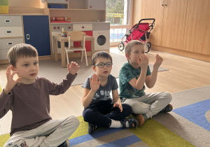 Dzieci pokazują znaki w języku migowym