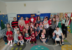 Dzieci wraz z rodzicami pozują do zdjęcia.