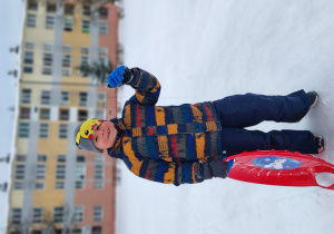 Chłopiec macha ręką.