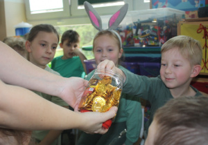 Chłopiec dostaje czekoladową monetę.